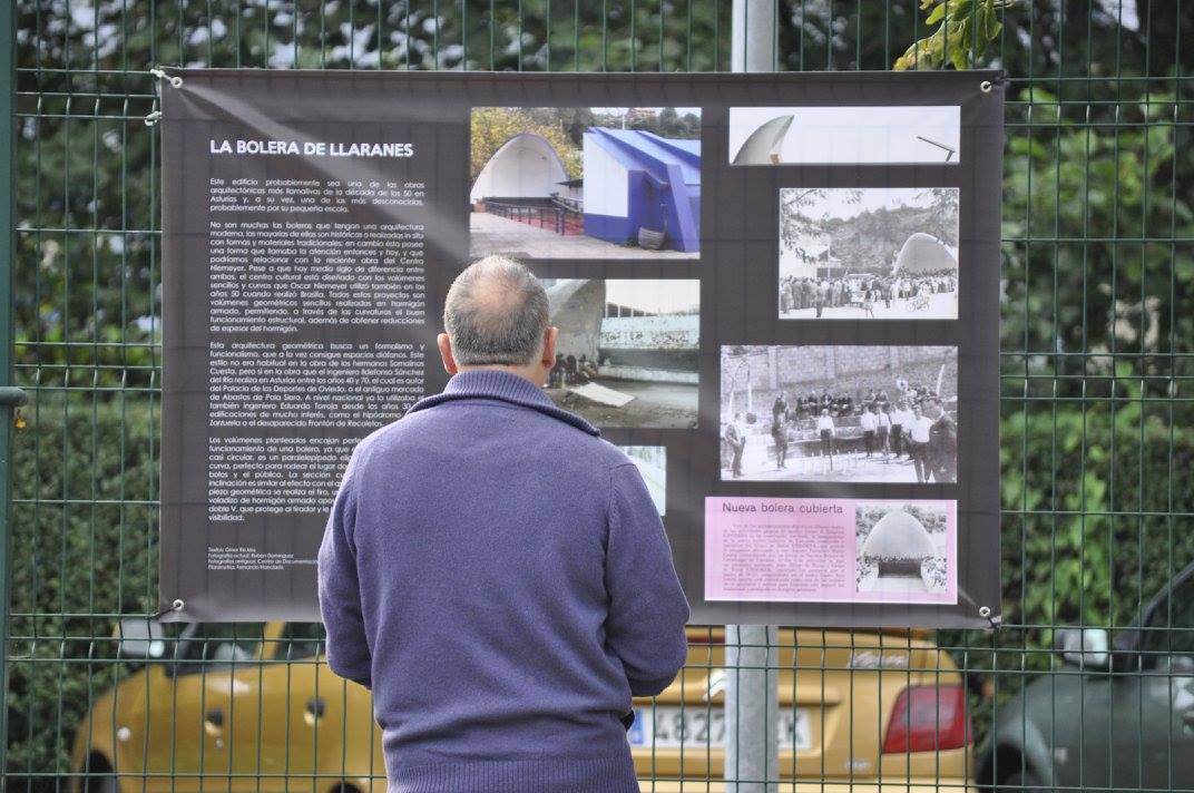 Foto de hombre de espaldas mirando cartel descriptivo de la bolera de Llaranes